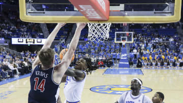 Mar 7, 2024; Los Angeles, California, USA; UCLA guard Sebastian Mack (12) attempts a layup as Arizona Wildcats center Motiejus Krivas (14) defends during the second half of a game at Pauley Pavilion presented by Wescom. Mandatory Credit: Yannick Peterhans-USA TODAY Sports