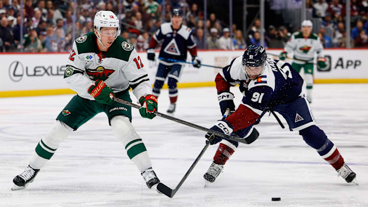 Mar 8, 2026; Denver, Colorado, USA; Colorado Avalanche left wing Nazem Kadri (91) steals the puck away from Minnesota Wild left wing Matt Boldy (12) in the first period at Ball Arena. Mandatory Credit: Isaiah J. Downing-Imagn Images