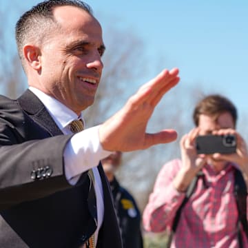 Iowa's new head men's basketball coach Ben McCollum waves at the assembled crowd while walking into his introductory press conference Tuesday, March 25, 2025 at Carver-Hawkeye Arena in Iowa City, Iowa.