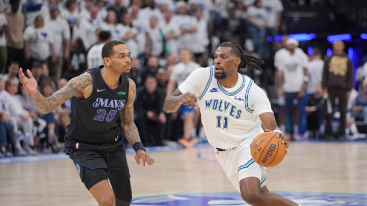 May 24, 2024; Minneapolis, Minnesota, USA; Minnesota Timberwolves center Naz Reid (11) controls the ball against Dallas Mavericks forward P.J. Washington (25) in the fourth quarter during game two of the western conference finals for the 2024 NBA playoffs at Target Center. Mandatory Credit: Brad Rempel-USA TODAY Sports