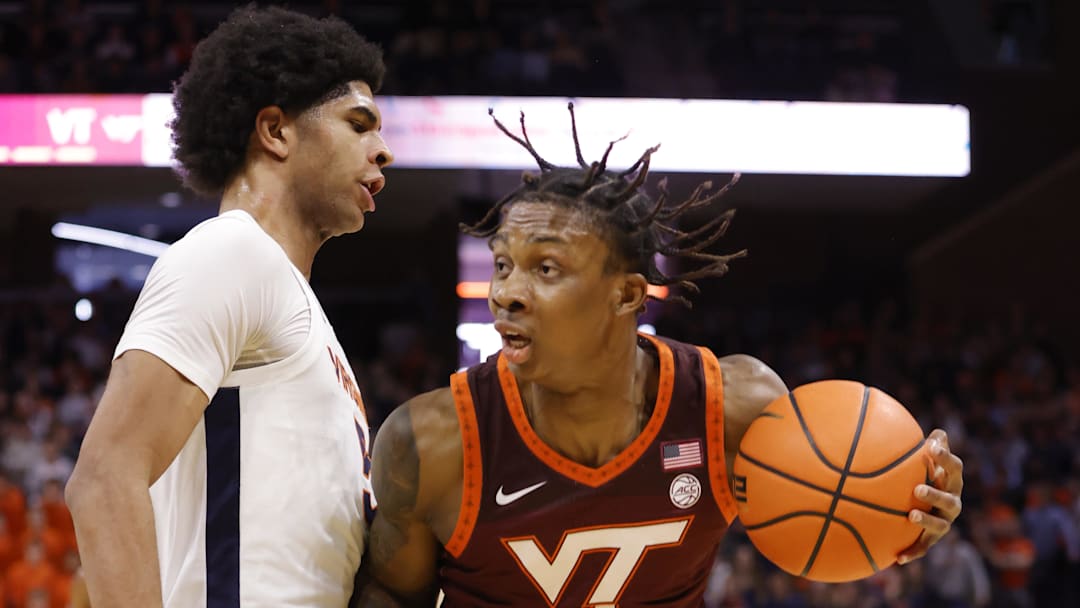 Feb 1, 2025; Charlottesville, Virginia, USA; Virginia Tech Hokies forward Tobi Lawal (1) controls the ball as Virginia Cavaliers forward Jacob Cofie (5) defends in the first half at John Paul Jones Arena. Mandatory Credit: Amber Searls-Imagn Images
