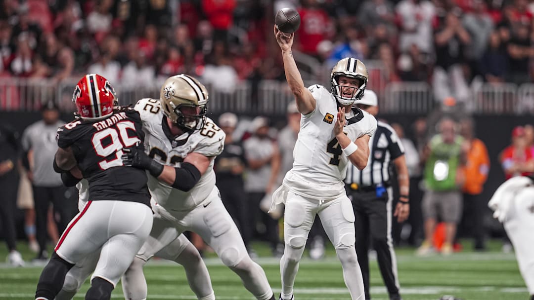 Sep 29, 2024; Atlanta, Georgia, USA; New Orleans Saints quarterback Derek Carr (4) passes the ball against the Atlanta Falcons during the second half at Mercedes-Benz Stadium.