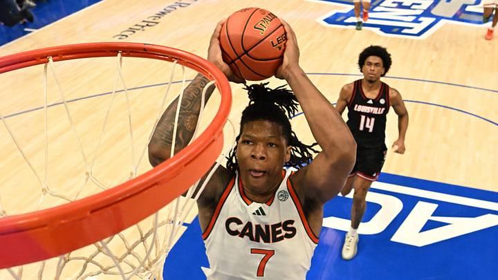 Mar 12, 2026; Charlotte, NC, USA; Miami (FL) Hurricanes forward Shelton Henderson (7) scores as Louisville Cardinals guard Adrian Wooley (14) defends in the second half at Spectrum Center. Mandatory Credit: Bob Donnan-Imagn Images