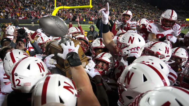 Members of the Nebraska football team celebrate with the trophy after beating Iowa, 24-17, on Friday, Nov. 25, 2022.