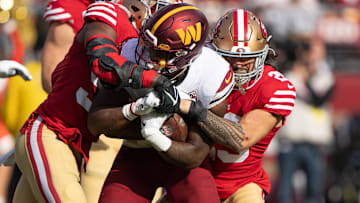 San Francisco 49ers linebacker Dre Greenlaw (57) and safety Talanoa Hufanga (29) tackle Washington Commanders running back Brian Robinson Jr. (8) during the first quarter at Levi's Stadium. 