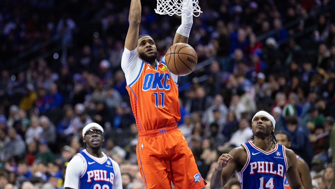 Jan 14, 2025; Philadelphia, Pennsylvania, USA; Oklahoma City Thunder guard Isaiah Joe (11) dunks in front of Philadelphia 76ers guard Ricky Council IV (14) during the second quarter at Wells Fargo Center.