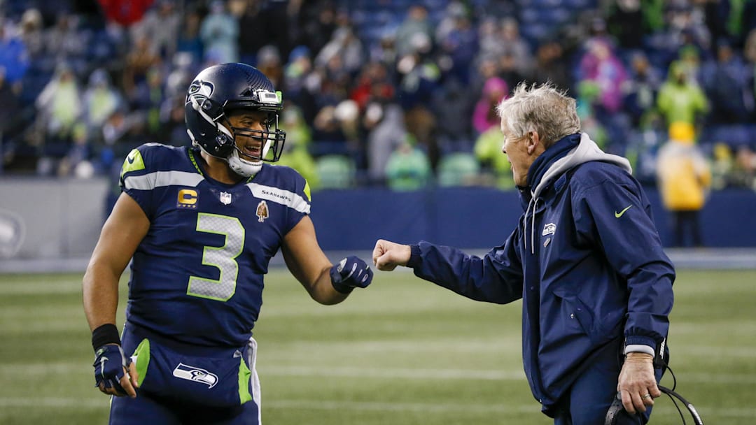 Jan 2, 2022; Seattle, Washington, USA; Seattle Seahawks quarterback Russell Wilson (3) bumps fists with head coach Pete Carroll during the fourth quarter two-minute warning against the Detroit Lions at Lumen Field. Mandatory Credit: Joe Nicholson-Imagn Images