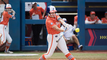 Jun 3, 2024;  Oklahoma City, OK, USA;  Florida Gators infielder Reagan Walsh (15) hits a double in the third inning against the Oklahoma Sooners during a Women's College World Series softball semifinal game at Devon Park. Mandatory Credit: Brett Rojo-Imagn Images