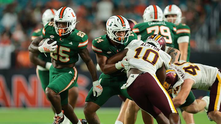 Sep 26, 2026; Miami Gardens, Florida, USA; Miami Hurricanes running back Chris Wheatley-Humphrey (25) runs with the football as Miami Hurricanes tight end Israel Briggs (14) blocks Central Michigan Chippewas linebacker Jeremiah Alston (10) during the fourth quarter at Hard Rock Stadium. Mandatory Credit: Sam Navarro-Imagn Images