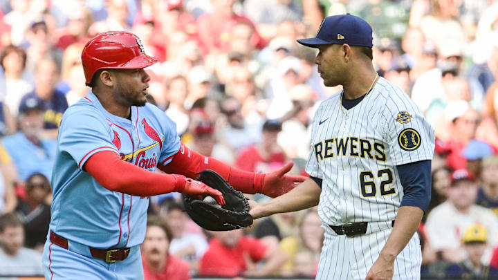 Jun 14, 2025; Milwaukee, Wisconsin, USA;  St. Louis Cardinals first baseman Willson Contreras (40) hands the ball back to Milwaukee Brewers starting pitcher Jose Quintana (62) after being hit by a pitch in the fifth inning at American Family Field. Mandatory Credit: Benny Sieu-Imagn Images