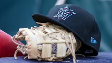 Apr 24, 2024; Atlanta, Georgia, USA; A detailed view of a Miami Marlins hat and glove in the dugout before a game against the Atlanta Braves at Truist Park. 