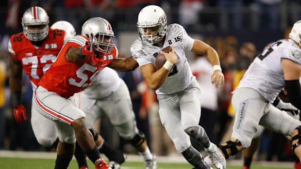 Oregon Ducks quarterback Marcus Mariota (8) avoids a rush by Ohio State Buckeyes defensive lineman Tyquan Lewis (59)