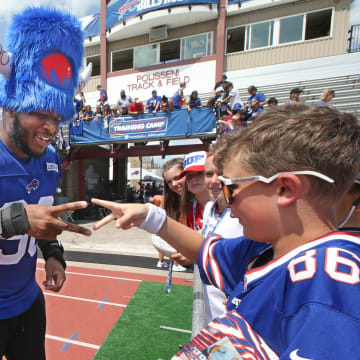 Bills defensive tackle DeWayne Carter looses a game of 'rock, paper, sissors' to fan Isaac Howlett, 11, Rochester, as he signs autographs at the end of day three. The pair were playing for Carter's wristbands, which Howlett won.