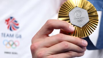 An athlete holds up a gold medal at the 2024 Paris Games.