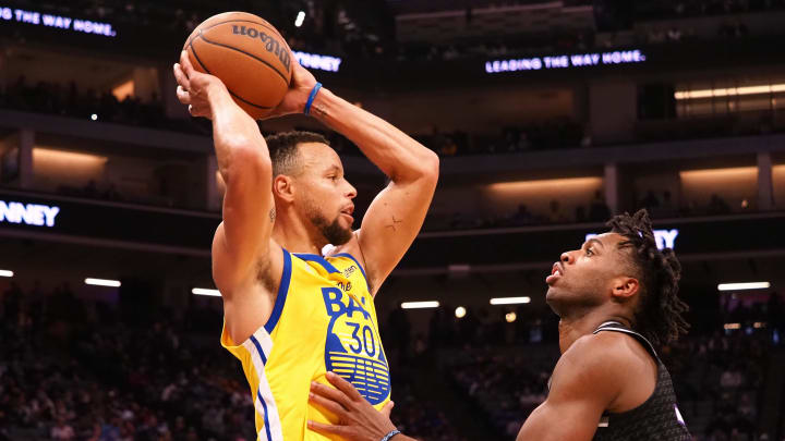 Warriors guard Stephen Curry controls the ball against Kings guard Buddy Hield during a game in October 2021.