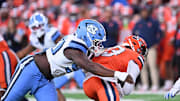 Oct 31, 2025; Syracuse, New York, USA; North Carolina Tar Heels defensive lineman Xavier Lewis (90) tackles Syracuse Orange quarterback Joseph Filardi (13) in the first quarter at the JMA Wireless Dome.