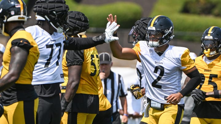 Jul 27, 2024; Latrobe, PA, USA; Pittsburgh Steelers quarterback Justin Fields celebrates with offensive tackle Broderick Jones (77) after scoring during training camp at Saint Vincent College. Mandatory Credit: Barry Reeger-USA TODAY Sports