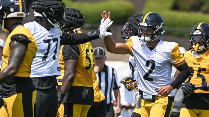 Jul 27, 2024; Latrobe, PA, USA; Pittsburgh Steelers quarterback Justin Fields celebrates with offensive tackle Broderick Jones (77) after scoring during training camp at Saint Vincent College. Mandatory Credit: Barry Reeger-USA TODAY Sports