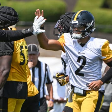 Jul 27, 2024; Latrobe, PA, USA; Pittsburgh Steelers quarterback Justin Fields celebrates with offensive tackle Broderick Jones (77) after scoring during training camp at Saint Vincent College. Mandatory Credit: Barry Reeger-USA TODAY Sports