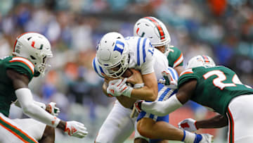Oct 22, 2022; Miami Gardens, Florida, USA; Duke Blue Devils quarterback Riley Leonard (13) protects the football after a run during the second quarter against the Miami Hurricanes at Hard Rock Stadium. Mandatory Credit: Sam Navarro-Imagn Images