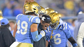 Nov 8, 2024; Pasadena, California, USA;   UCLA Bruins defensive coordinator Ikaika Malloe, center, celebrates with linebacker Carson Schwesinger (49) defensive back Jaylin Davies (6) after an interception in the second half against the Iowa Hawkeyes at the Rose Bowl. Mandatory Credit: Jayne Kamin-Oncea-Imagn Images