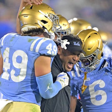 Nov 8, 2024; Pasadena, California, USA;   UCLA Bruins defensive coordinator Ikaika Malloe, center, celebrates with linebacker Carson Schwesinger (49) defensive back Jaylin Davies (6) after an interception in the second half against the Iowa Hawkeyes at the Rose Bowl. Mandatory Credit: Jayne Kamin-Oncea-Imagn Images