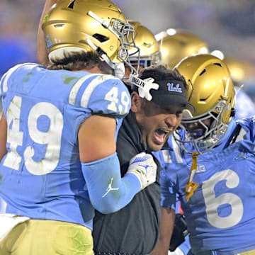 Nov 8, 2024; Pasadena, California, USA;   UCLA Bruins defensive coordinator Ikaika Malloe, center, celebrates with linebacker Carson Schwesinger (49) defensive back Jaylin Davies (6) after an interception in the second half against the Iowa Hawkeyes at the Rose Bowl. Mandatory Credit: Jayne Kamin-Oncea-Imagn Images