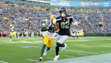 Aug 23, 2025; Green Bay, Wisconsin, USA;  Seattle Seahawks wide receiver Cody White (82) is pushed out of bounds by Green Bay Packers cornerback Micah Robinson (26) after catching a pass during the fourth quarter at Lambeau Field. Mandatory Credit: Jeff Hanisch-Imagn Images