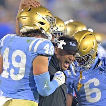 Nov 8, 2024; Pasadena, California, USA;   UCLA Bruins defensive coordinator Ikaika Malloe, center, celebrates with linebacker Carson Schwesinger (49) defensive back Jaylin Davies (6) after an interception in the second half against the Iowa Hawkeyes at the Rose Bowl. Mandatory Credit: Jayne Kamin-Oncea-Imagn Images
