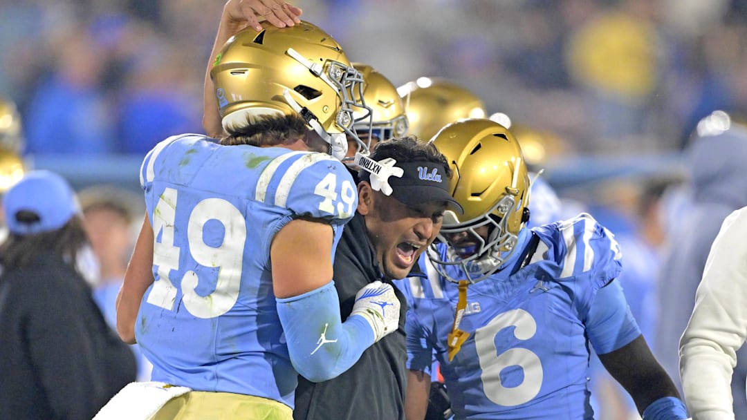 Nov 8, 2024; Pasadena, California, USA;   UCLA Bruins defensive coordinator Ikaika Malloe, center, celebrates with linebacker Carson Schwesinger (49) defensive back Jaylin Davies (6) after an interception in the second half against the Iowa Hawkeyes at the Rose Bowl. Mandatory Credit: Jayne Kamin-Oncea-Imagn Images