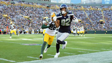 Aug 23, 2025; Green Bay, Wisconsin, USA;  Seattle Seahawks wide receiver Cody White (82) is pushed out of bounds by Green Bay Packers cornerback Micah Robinson (26) after catching a pass during the fourth quarter at Lambeau Field. Mandatory Credit: Jeff Hanisch-Imagn Images