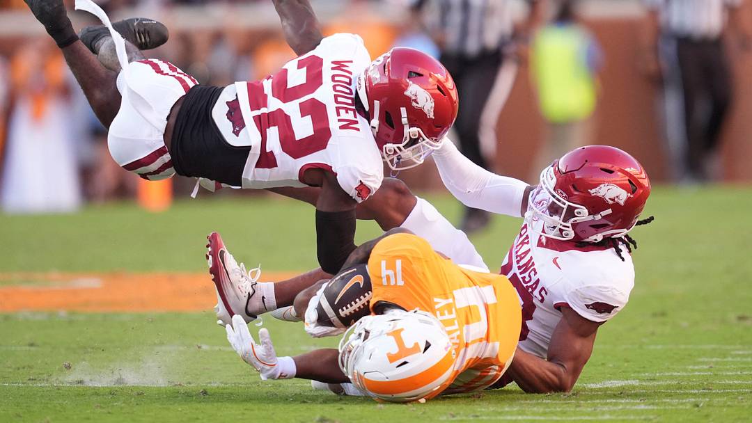 Tennessee wide receiver Braylon Staley (14) is brought down by Arkansas defensive backs Caleb Wooden (22) and Julian Neal (23) in an NCAA college football game on Oct. 11, 2025, in Knoxville, Tennessee.