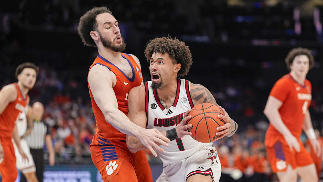 Mar 14, 2025; Charlotte, NC, USA;  Louisville Cardinals guard J'Vonne Hadley (1) makes contact with Clemson Tigers guard Jaeden Zackery (11) during the second half at Spectrum Center. Mandatory Credit: Jim Dedmon-Imagn Images