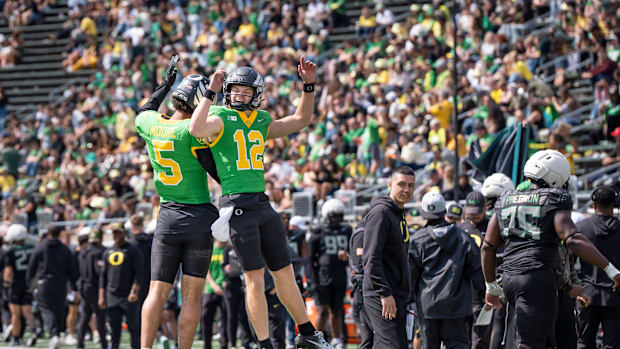 ombat Ducks quarterback Dante Moore, left, and quarterback Brock Thomas celebrate as the Fighting Ducks face off against Migh