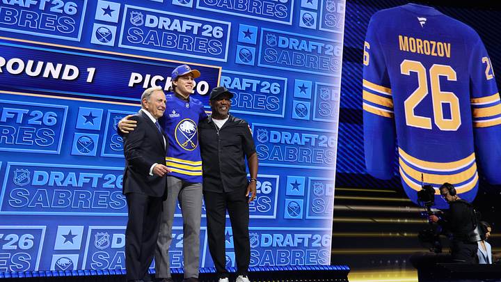 Jun 26, 2026; Buffalo, New York, USA; Ilia Morozov reacts beside NHL commissioner Gary Bettman and former Buffalo Bills player Thurman Thomas after being selected with the twentieth pick in the first round of the 2026 NHL Draft by the Buffalo Sabres at KeyBank Center. Mandatory Credit: Timothy T. Ludwig-Imagn Images