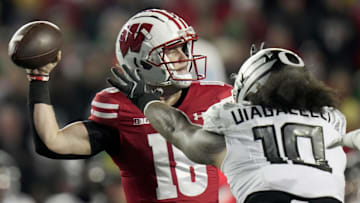 Wisconsin quarterback Braedyn Locke (18) is pressured by Oregon defensive end Matayo Uiagalelei (10) during the first quarter of their game Saturday, November 16, 2024 at Camp Randall Stadium in Madison, Wisconsin.