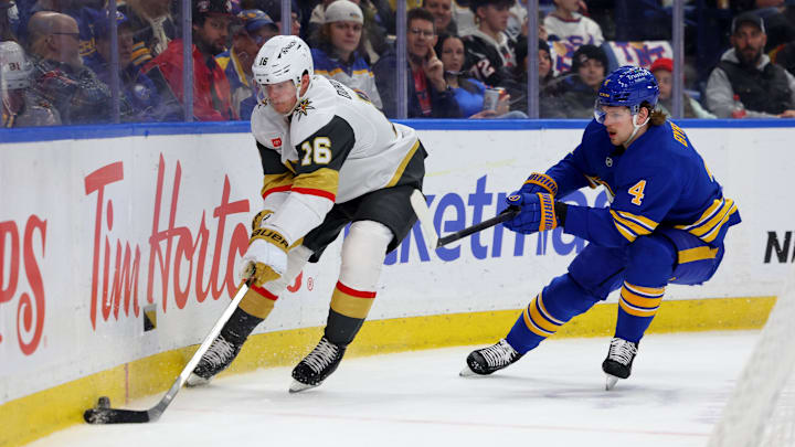 Pavel Dorofeyev plays the puck, with Bowen Byram following