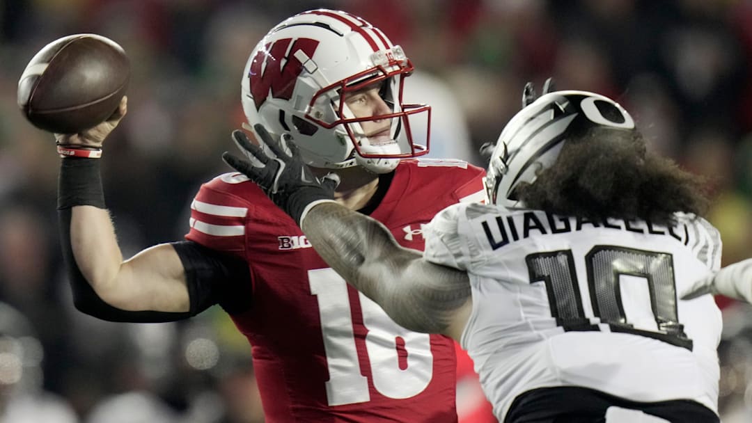 Wisconsin quarterback Braedyn Locke (18) is pressured by Oregon defensive end Matayo Uiagalelei (10) during the first quarter of their game Saturday, November 16, 2024 at Camp Randall Stadium in Madison, Wisconsin.