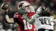 Wisconsin quarterback Braedyn Locke (18) is pressured by Oregon defensive end Matayo Uiagalelei (10) during the first quarter of their game Saturday, November 16, 2024 at Camp Randall Stadium in Madison, Wisconsin.