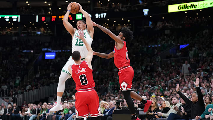 Jan 9, 2023; Boston, Massachusetts, USA; Boston Celtics forward Grant Williams (12) grabs the rebound against Chicago Bulls guard Zach LaVine (8) and guard Coby White (0): David Butler II-Imagn Images