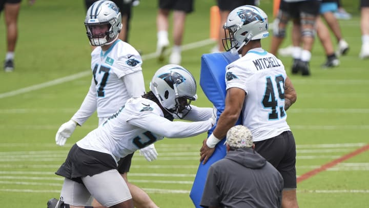 Jun 4, 2024; Charlotte, NC, USA; Carolina Panthers linebacker DJ Johnson (52) hits the blocking dummy during OTAs. Mandatory Credit: Jim Dedmon-USA TODAY Sports