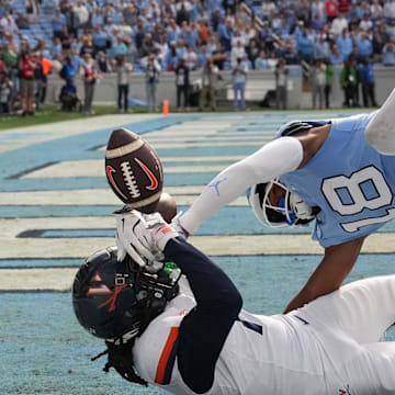 Oct 25, 2025; Chapel Hill, North Carolina, USA; North Carolina Tar Heels defensive back Jaiden Patterson (18) breaks up a pass in the end zone intended for Virginia Cavaliers wide receiver Jahmal Edrine (7) in overtime at Kenan Stadium. Mandatory Credit: Bob Donnan-Imagn Images