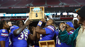 Dec 20, 2024; Tampa, FL, USA; Florida Gators defensive lineman D'Antre Robinson (35) and quarterback DJ Lagway (2)  hold up the Gasparilla Bowl championship trophy after the win against the Tulane Green Wave at Raymond James Stadium. Mandatory Credit: Kim Klement Neitzel-Imagn Images