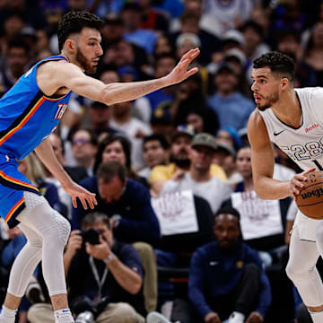 May 15, 2025; Denver, Colorado, USA; Denver Nuggets forward Michael Porter Jr. (1) controls the ball as Oklahoma City Thunder forward Chet Holmgren (7) guards in the second quarter during game six of the second round for the 2025 NBA Playoffs at Ball Arena. Mandatory Credit: Isaiah J. Downing-Imagn Images