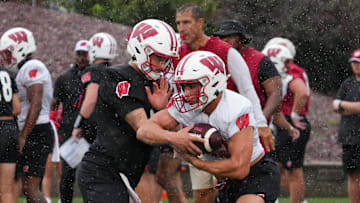 Wisconsin running back Harrison Bortolotti (32) takes a handoff from quarterback Hunter Simmons (15) during football practice, July 30, 2025, at Ralph E. Davis Pioneer Stadium in Platteville, Wisconsin.