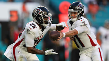 Aug 11, 2023; Miami Gardens, Florida, USA;  Atlanta Falcons quarterback Logan Woodside (11) hands off to running back Carlos Washington Jr. (28) against the Miami Dolphins in the first quarter at Hard Rock Stadium. Mandatory Credit: Nathan Ray Seebeck-Imagn Images