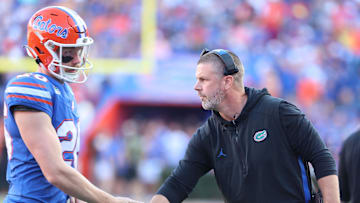 Nov 16, 2024; Gainesville, Florida, USA; Florida Gators head coach Billy Napier high fives Florida Gators punter Jeremy Crawshaw (26) against the LSU Tigers   during the first half at Ben Hill Griffin Stadium. Mandatory Credit: Kim Klement Neitzel-Imagn Images