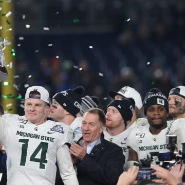 Dec 27, 2019; Bronx, New York, USA; Michigan State quarterback Brian Lewerke (14) holds up the MVP trophy after defeating the Wake Forest Demon Deacons in the Pinstripe Bowl at Yankee Stadium. Mandatory Credit: Brad Penner-USA TODAY Sports