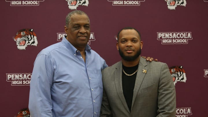 New Pensacola boys basketball head coach David Williams II (right) stands with his father, David Williams, who was the Tigers' longtime head coach from 1986-2004, after Williams II is announced as the team's coach at Pensacola High School on Monday, April 21, 2025.