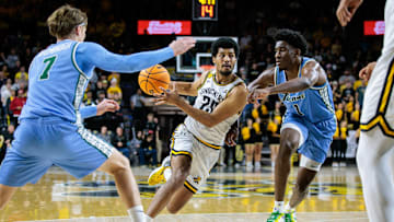 Feb 23, 2025; Wichita, Kansas, USA; Wichita State Shockers guard Harlond Beverly (20) drives to the basket around Tulane Green Wave forward Kaleb Banks (1) during the second half at Charles Koch Arena. 